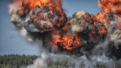 Image of Intense explosion with fire and black smoke and sky in the background