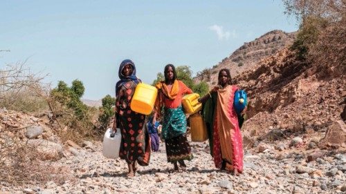 Internally displaced women carry jerrycans in the makeshift camp where they are sheltered in the ...