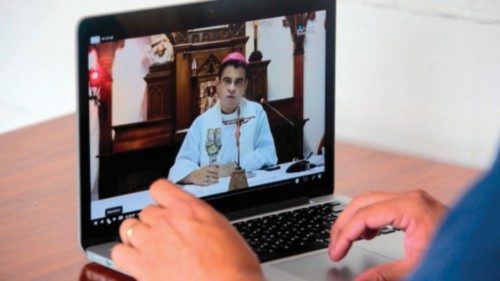 A man watches the mass of Monsignor Rolando Alvarez via Facebook in Managua, on August 11, 2022. - A ...