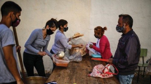 Women serve food at a soup kitchen at the Puerta de Hierro neighborhood, in La Matanza municipality, ...