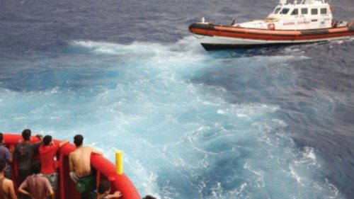 Migrants on board of NGO Proactiva Open Arms Uno rescue boat looks at boat Guardia Costiera that ...