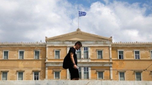 A man makes his way in front of the Greek parliament building in Athens, Greece, August 8, 2022. ...