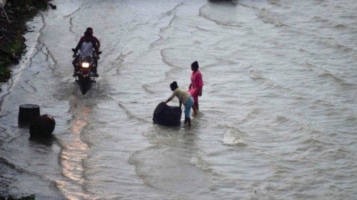 People wade along a flooded street on the banks of river Ganges in Allahabad on August 21, 2022. ... People wade along a flooded street on the banks of river Ganges in Allahabad on August 21, 2022. ...