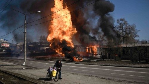 (FILES) In this file photo taken on March 25, 2022 A man flees with his belongings as fire engulfs a ... (FILES) In this file photo taken on March 25, 2022 A man flees with his belongings as fire engulfs a ...