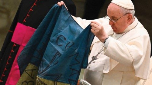 Pope Francis holds a flag of Ukraine that comes from the city of Bucha, one of the areas around ...