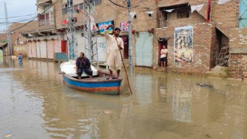 A resident makes his way on a boat along a waterlogged street after a heavy monsoon rainfall in ...