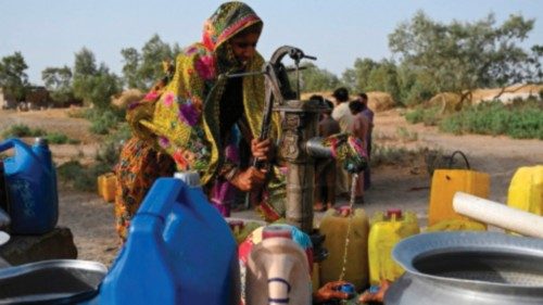 In this picture taken on May 11, 2022, a woman fills cans with water from a hand pump during a ...