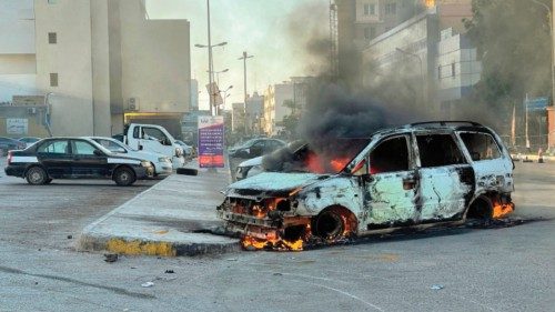 TOPSHOT - Damaged vehicles are pictured in a street in the Libyan capital Tripoli on August 27, ...