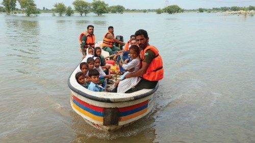 TOPSHOT - Rescue workers use a boat to drop children back home after school in a flood hit area ...