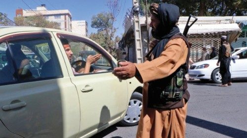 Taliban fighters stop motorists on a road after a blast outside a mosque in Herat in western ...