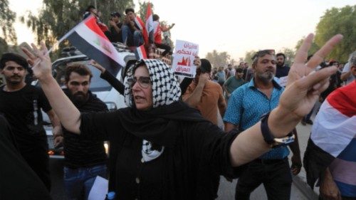 epa10155779 An Iraqi woman carries the Iraqi national flag during a protest near the Supreme ...