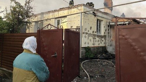 A local resident looks at Ukrainian firefighters put out fire in a residential house after a Russian ... A local resident looks at Ukrainian firefighters put out fire in a residential house after a Russian ...