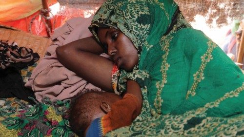 FILE PHOTO: Abdia Aden Mohamed rests with her 8-month-old child Ayan Hassan inside their makeshift ...