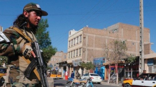 A Taliban fighter stands guard along a road after a blast during the Friday prayer in Gazargah ...