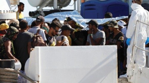 Migrants wait to disembark from the Italian coast guard vessel Dattilo that was transferring them ...