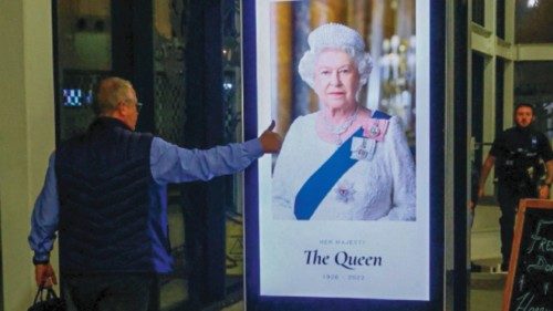 A man gestures towards an image of Queen Elizabeth, Britain's longest-reigning monarch and the ...