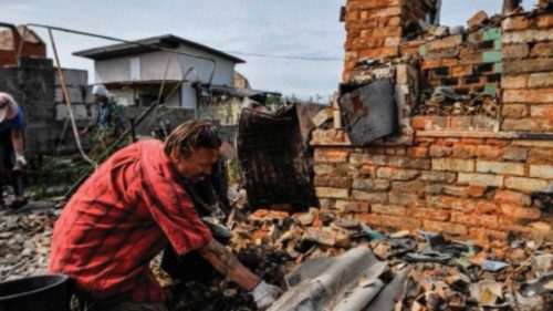 Volunteers clear the rubble of a destroyed house as a result of shelling in village of Moshchun, ...