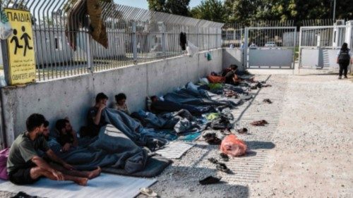 Yazidi migrants from Iraq wait for the entry into a refugee camp in Serres, northern Greece, on ...