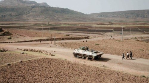 (FILES) In this file photo taken on June 20, 2021 People walk near a tank of alleged Ethiopian army ...