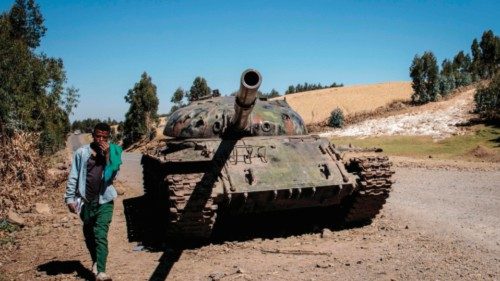 (FILES) In this file photo taken on December 06, 2021 A young man walks past a destroyed tank near ...