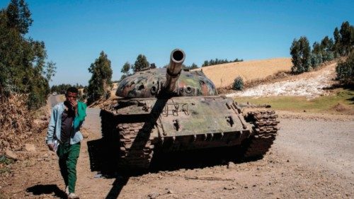 (FILES) In this file photo taken on December 06, 2021 A young man walks past a destroyed tank near ... (FILES) In this file photo taken on December 06, 2021 A young man walks past a destroyed tank near ...