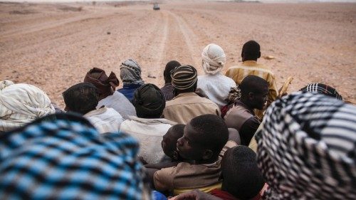 Migrants headed to Libya are wedged into the back of a pickup truck as it drives north through the ...