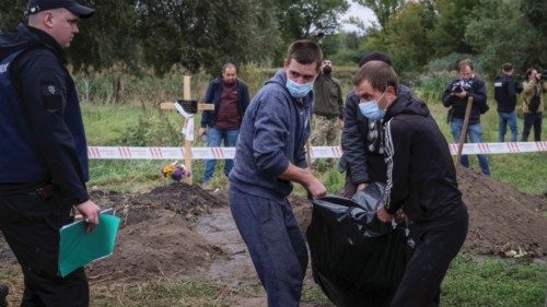 A police officer looks on as workers carry the body of a person who, according to Ukrainian police, ... A police officer looks on as workers carry the body of a person who, according to Ukrainian police, ...