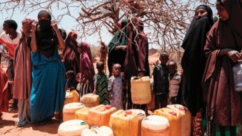 People wait to fill their water tanks as they receive water delivery by the Save the Children twice ...