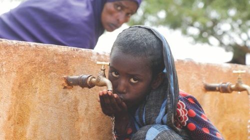 FILE PHOTO: Somali displaced girl Sadia Ali, 8, drinks water from a tap at the Kaxareey  camp for ...