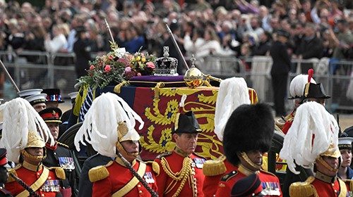 The coffin of Queen Elizabeth II, draped in the Royal Standard, travels on the State Gun Carriage of ...