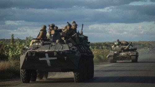 Ukrainian servicemen ride on Armoured Personnel Carrier (APC) and a tank, as Russia's attack on ...