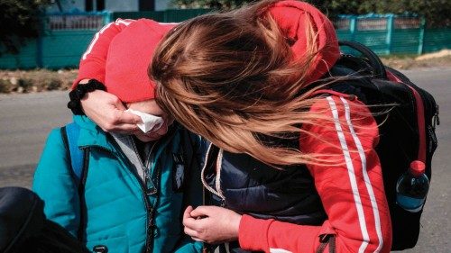 Twelve-year-old Lila (C) is comforted by her sister Yana (2ndR) as they look for a transport to ...