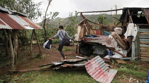 A woman removes rubble from her destroyed house in the rural zone of  Cuey, in the aftermath of ...