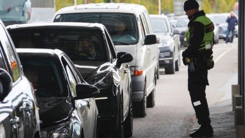 A Finnish border guard officer stands near cars queued to enter Finland from Russia in Vaalimaa, ...