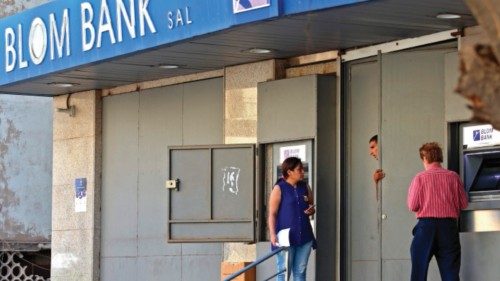 Lebanese depositors withdraw money from an ATM machine outside BLOM bank in Beirut on September 26, ...
