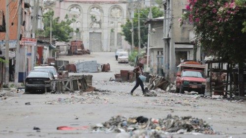 FILE PHOTO: A man walks between road blocks set up by gangs after they waged intense gun battles, ... FILE PHOTO: A man walks between road blocks set up by gangs after they waged intense gun battles, ...