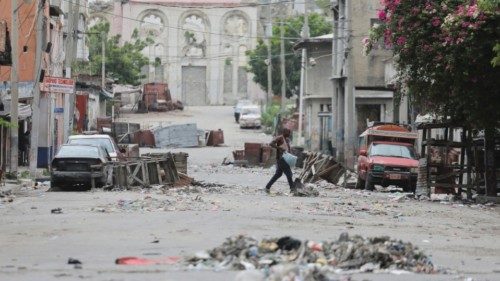 FILE PHOTO: A man walks between road blocks set up by gangs after they waged intense gun battles, ...