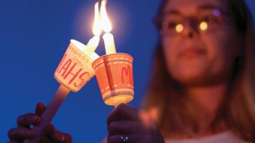 People holding candles take part in a candlelight vigil for Mahsa Amini who died in custody of ...