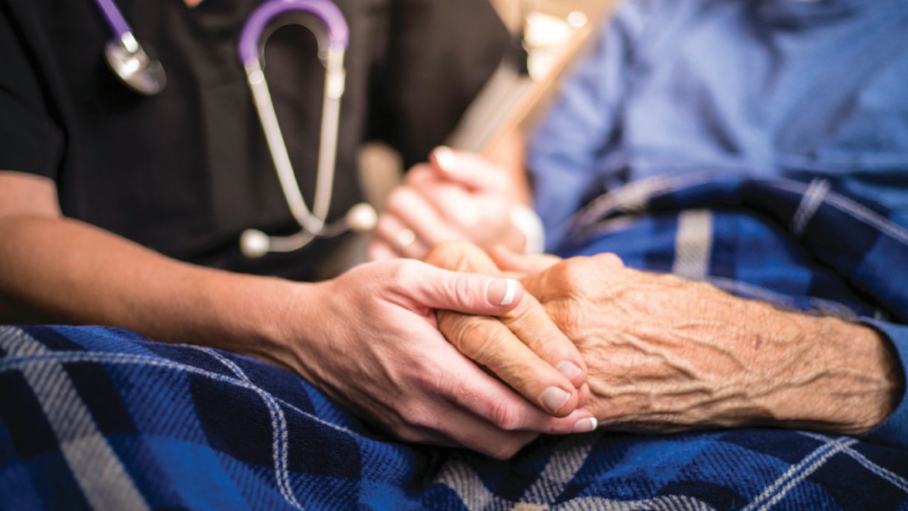 A stock photo of a Hospice Nurse visiting an Elderly male patient who is receiving ...