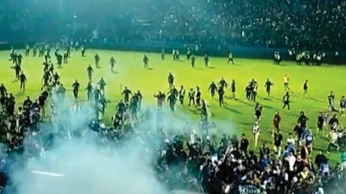 This screengrab of an AFPTV video taken on October 1, 2022 shows tear gas in the crowd as people run ...