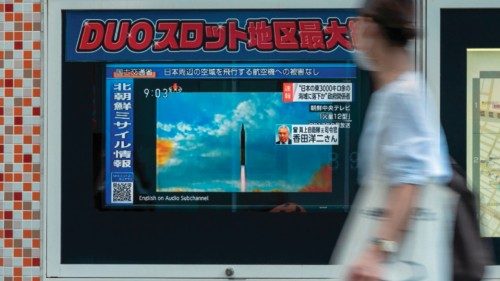 TOPSHOT - A woman walks past a public television screen in Tokyo on October 4, 2022, displaying file ...