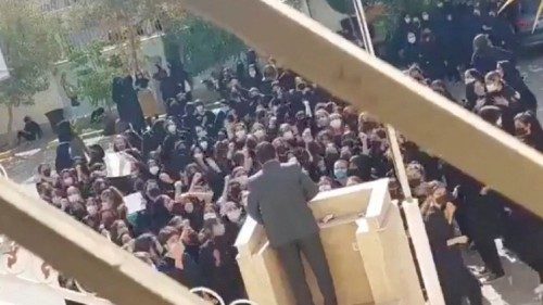 Female protesters react and chant towards a man standing at a podium in Shiraz, Fars province, Iran ...