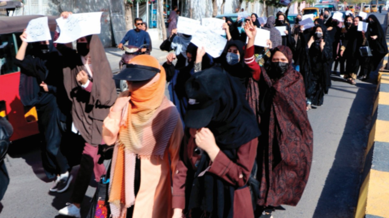 Afghan female students chant 'Education is our right, genocide is a crime' during a protest as they ...