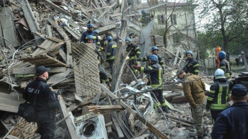 Rescuers work at the site of a residential building heavily damaged by a Russian missile strike, ...