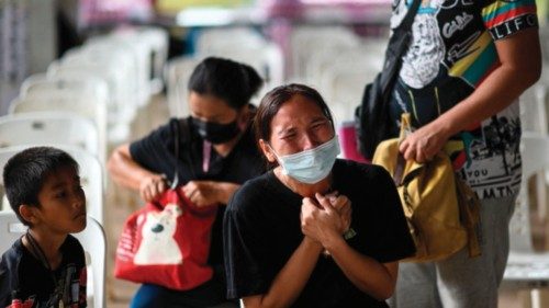 TOPSHOT - A child sits next to the mother of a victim as she cries outside the nursery, where a ...