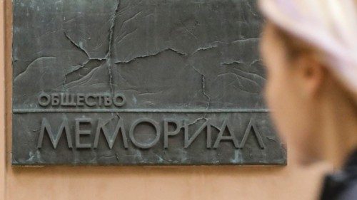 epa10229025 A woman walks past a signboard reading 'The society of Memorial' at the entrance to the ...