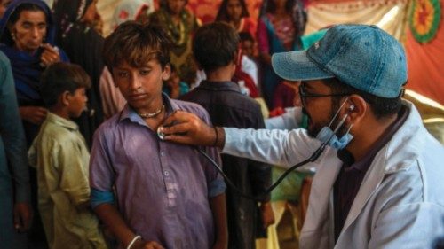 In this picture taken on September 27, 2022, a Pakistani paramedic examines a child at a medical ...