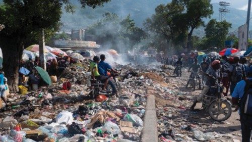 epa10231898 People move through a street covered with garbage that has not been collected, in ...