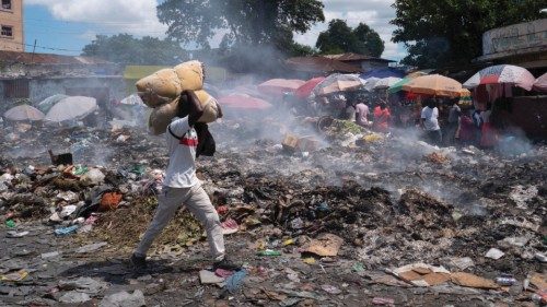 epa10231890 A man walks down a street littered with garbage that has not been picked up, in ...