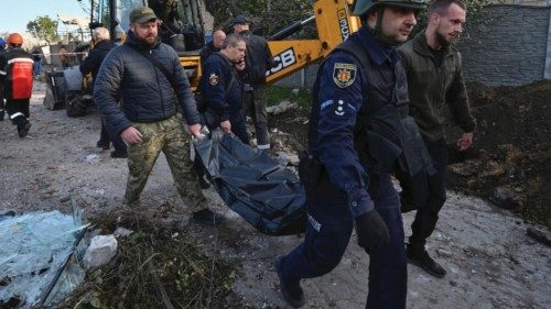 Rescuers and volunteers carry a bag with the body of a civilian person found dead at a residential ...